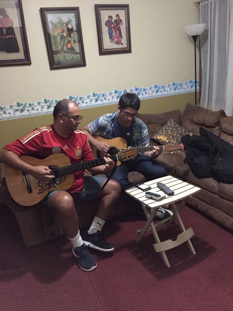 Spanish immersion participant playing guitar with his host dad!